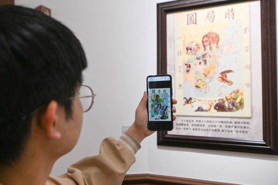 في الصورة الملتقطة يوم 30 أبريل 2023، زائر يستخدم تكنولوجيا الواقع المعزز على هاتف محمول في متحف ليانغ تشي تشاو في بلدية تيانجين شمالي الصين. (شينخوا)