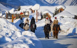 في الصورة الملتقطة يوم 5 فبراير 2024، زوار يركبون الخيول في قرية خمو في ولاية آلتاي في منطقة شينجيانغ الويغورية ذاتية الحكم بشمال غربي الصين. (شينخوا)